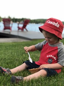 Boy eating ice cream by the water on Canada Day