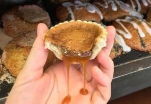 Dripping butter tart in a hand from Dooher's Bakery in Campbellford Trent Hills Ontario