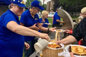 Rotarian pouring syrup on pancakes _ pancake breakfast for canada day